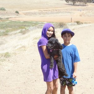Maya Raval and Devin Raval carry miss Angel (thisaway boat dog)