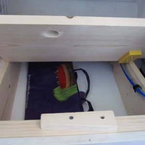 Media '7 under aft section' in album 'Sink cover board while varnishing.  I made a similar one (sans hole) for the cutout where the Wallas used to be.  It's surprisingly handy to be able to remove it to work on things (wiring etc.) under the galley, although I may eventually replace the whole galley counter and if so will likely make it a solid piece except for the sink cutout.'