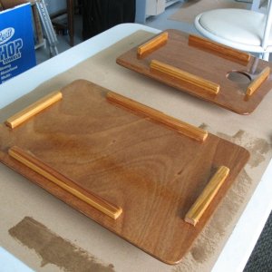 Media 'Making a set of "usable mock-up from scrap" cover boards for the sink and former-Wallas hole in the galley counter.  Two sheets of scrap 1/8" ply epoxied together to make 1/4", then cut and cleats affixed to the bottom side to hold them in place, and then varnished.  Turns out they make sort of handy "butler's trays" when used upside down at anchor.' in album 'Sink cover board while varnishing.  I made a similar one (sans hole) for the cutout where the Wallas used to be.  It's surprisingly handy to be able to remove it to work on things (wiring etc.) under the galley, although I may eventually replace the whole galley counter and if so will likely make it a solid piece except for the sink cutout.'