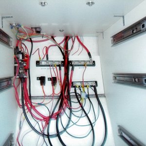 (AnchortownJim) Glued a piece of 3/4" marine plywood to the hull with 3M 4200.  Mounted the DC bus bars, one for the switched house circuits, one for non-switched and a common ground bus.  This was driven by the installation of the windless.