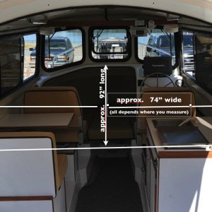 The cabin, shown with the bulkhead removed in Les' photo on Facebook, in our view is quite large.  One could argue that it is really 7' 7" long, and the 5' 9" berth extends out 18" into the cabin, which allows a person to sit on the berth while visiting with three other people in the cabin, as well as allowing easy access to the portable toilet under the center cushion.  Of course, when the left, rear cushions are put into place, the berth extends to a total length of 7', reducing the floor space in the cabin at night.  Visually however, the cabin still looks 7' 7"' long.  That's the genius of this design.  Please notice, too, the width of the floor in front of the dinette and galley:  it is wide enough for two people to easily pass one another, which we feel is an important feature for living comfortably in a small boat.