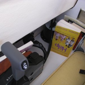 The space between the helm seat and galley cabinet, and right of throttle, is great for books and maps