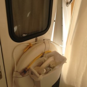 Double duty:  the life preserver hook on the bulkhead also serves as a nifty holder for a waste basket.  We cut a slot in the lip of the basket, and use recycled plastic grocery bags as a liner for the trash.