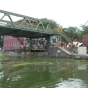 Media 'Town lift bridge in up position.  Here, the train tracks were just to the north of the canal, so when a train was going by there was quite a traffic jam.  Lots of tourists in town and one of the things to do way take pictures of the boats going under the bridge.' in album 'Headed east, we spent our first night in a road side rest in Lolo Nat Forest.  We were greeted by the sun and a horse group setting out on a trail.  Good way to start a boat journey.'