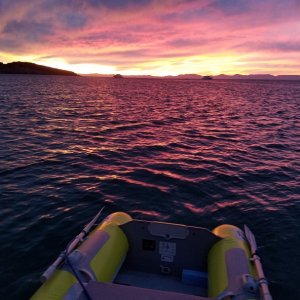 The start of a great sunset as the shrimp are on the barby. A couple of big superyachts anchored farther out and the mountains of Baja in the background.