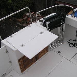 Removed cushion, added fold out table that is support with hinged bracket, added tie down brackets to hold folding chairs. Velcro on transom door keeps it open when needed
