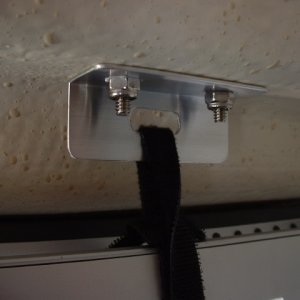 Made this bracket to hold the TV in stowed position. Through bolted with stainless machine screws. Mount is very sturdy in stowed position as the top edge of the TV rests on the top edge of our teak curtain strip.