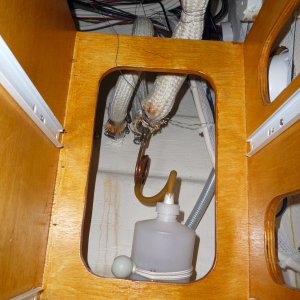 Media '10. Exhaust over flow collection bottle. I still get a little water getting past the heat resistant silicone used in the flex pipe to solid pipe connections, and possibly the flex pipe itself. I keep a synthetic towel folded under the cabinet drawer box, shown in this picture. The amount of water that collects in the towel and the bottle are minimal and now acceptable to me. It now takes pretty rough weather conditions to have salt water collect in these areas.' in album '1. Original exhaust vent on the outside of the hull.'