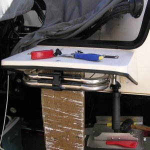 Swim step removal.  The tools; a sharpened putty knife, nylon spatula,heat gun, rubber mallet, 2X6 & a floor jack.  You can see the step actually bending under the load but not budging.