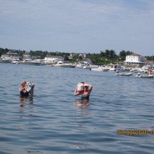 Ginny and Jess wading ashore  to go to the beach. They got offered a dingy ride by two nice guys but decided to hoof it anyway in Block Island. You can just see the back of Will-C to the right. To cheap to call for the three dollar launch