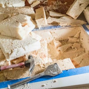 I used a large chisel and a hammer to pry pieces out. The foam was dry until I got to the very bottom, next to the hull, where it was damp.
