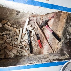 I used a metal pipe with one end sharpened as a coring tool to remove the foam under the portable toilet storage area. The wooden dowel is used to push the foam core plugs out of the pipe. The end goal was a tunnel that passes under the inspection hole and to the other side, just forward of the cored hull bottom, for battery cables to pass through.