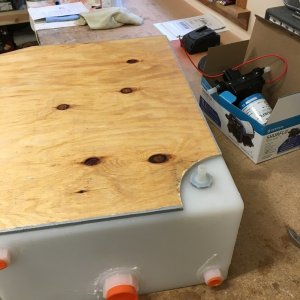 Tank upside down on workbench with platform cutout.