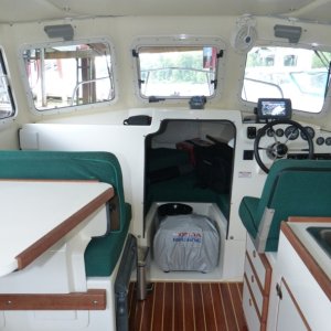 I got tired of things falling off the overhead shelf when the boat starts bouncing.  I wanted to close it off without taking away any accessibility and useability of the full shelf width.  Simply turn both spring loaded latches and the door swings down offering full access.  Made it out of sapele finished with oil.  Matches the teak fairly well.