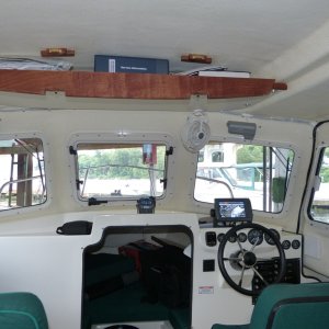 The overhead door drops open offering full access to the shelf.  The stops are epoxied to the roof.  My Honda BF90 service manual still fits easily.