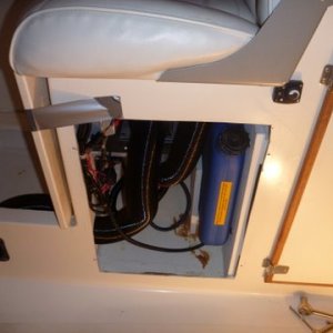 GETTING DOOR MADE TO MATCH THE OTHERS AS REFRID DOOR PREVIOUSLY COVERED THIS AREA NOTE SMALL CONTROLLER FOR HEATER UNDER REAR OF HELM SEAT. AREA FOR HEATER ABOUT 16'' WIDE X 21'' HIGH. DUCT TAPE HOLDING FLOOR BOARD UP SO I COULD TIGHTEN HOSE CLAMP ON DUCT,