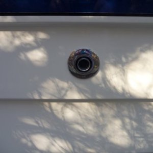 Media 'drilled oversize hole to provide 3/8''  clearance from the thru hulls tube to any surrounding fiberglass. Used one heat resistant fiber washer inside under flange nut, 5200 under the stationary flange on the outside.Purchased new exhaust items for the heater from Ocean Options 7416 Edgewood Road Annapolis, Md. 21403 phone 410 268 9365 ask for Dave' in album 'Basic mounting under the helm seat where refridgerator was removed. Fresh air intake under right side of seat box just beyond the heater on the left from this view. Heat exhaust under foot box in the helm seat area. Mount made out of 1/4 inch aluminum and 3x4 aluminum angle bolted to front of helm seat box. The four bolts up top are the existing four bolts for the helm seat. I used them for securing the extra long wires from my outboard motor controls and on off switch, bolted fuse holders etc, the heater sits right under the helm seat. What's different also is the hot air exhaust has been changed to 3" instead of the normal two inch, as I will add a Y pipe for a second duct if need be. From what I noticed so far a second duct won't be needed. This heater puts out better than an ugly girl on prom night.'