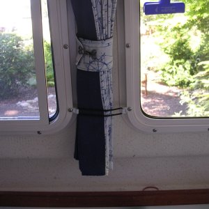Media 'Secured curtain.  Keeps the curtains from swinging back and forth, which was annoying while trolling for salmon and trying to watch downrigger rods.' in album 'House battery beneath Wallis against aft bulkhead. GFI outlet above fed by shore power and feeds battery tender/charger and extension cord by helm station.'