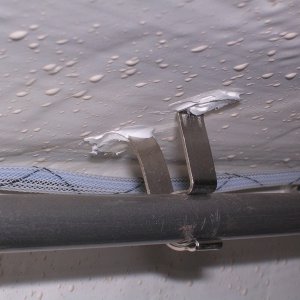 Media 'Curtain rod holder glued to cabin roof with 5200' in album 'House battery beneath Wallis against aft bulkhead. GFI outlet above fed by shore power and feeds battery tender/charger and extension cord by helm station.'