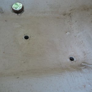 Tube removed, inside view (upper left corner).  The smaller holes are where a bilge pump had been fastened with screws.  Even though this "sump" area is depressed, there is still core in it.  Luckily it was all dry. Here I have enlarged the holes slightly and dug out a bit of core all the way around.  I then filled them (and then later cut the whole area out, but that's later...)