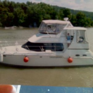the original,"Misty Seas" 2000 carver, linda is standing at the aft cockpit side door waving and i'm at the helm, picture taken while cruising on the ohio river, mile marker 471.