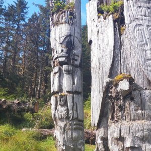 The mortuary poles are distinguished by being "upside down" with the thicker part of the tree at the top.  That allows for more room for the cavity holding the deceased persons bones and belongings (all of which was pilfered long ago).