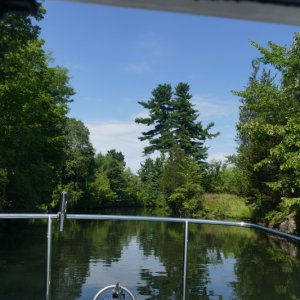 Typical Rideau entrance canal into a lock with solid granite to starboard.