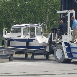 Brand new forklift driver picking up the brand new boat from the work stand.  The experienced driver there for support.