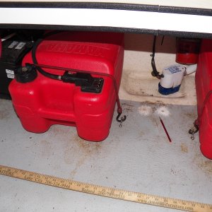 On the original setup, the fuel filter was between the tanks and screwed to the deck.  It's now hung temporarily from an outboard bolt (above the bilge pump) and exploratory holes have been drilled to find out the condition of the balsa core where it has been breached to install hold-downs for the various gear.
