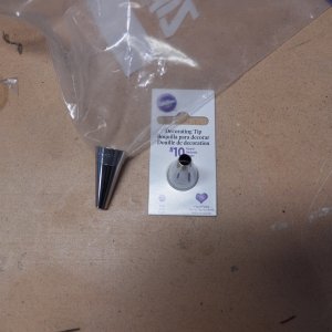 To get epoxy putty into the thin core area around the hatch, I used a home made grout bag.  I bought cake decorating tips (and the silicon frosting spreader shown in the prior picture) and loaded the baggy up with epoxy putty.  If you get the putty too stiff, it will blow out the bag.  Too thin and it will not stay in the slot.  After filling an area, I used tape to keep the putty in place.