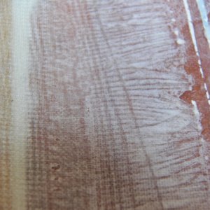 Here is a close up of the edge.  I removed some of the warp (or weft) from the edges to make the layers lie down and fair in better.  The horizontal light line under the fiberglass is lightly colored epoxy putty at the edge of the repair.  The difference in colors made it easy to see where to place the fabric layers.