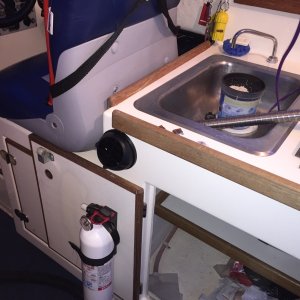 Hot air vent installed just behind helm seat, on front of cabinet under sink.