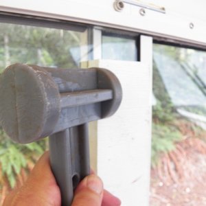 This is the sliding window on the other side.  I decided that removing it for a template to take to the glass shop would be the easiest way to get the proper fit.  I'm using a piece of "plastic wood" and a plastic hammer.