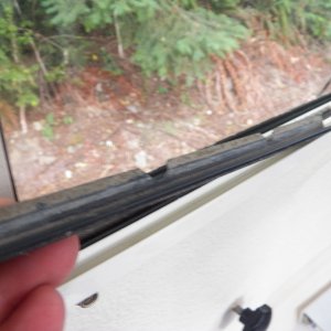 Media 'A grubby sliding strip showing why the C-Dory windows lose their slipperiness.  Installation is the reverse of removal, but getting the plastic strips to set back in right was time consuming.  They "click" in to place when everything is lined up properly.  The little tempered glass replacement was about $100 and took a couple of days.  The glass shop in Seattle had to send it out to get the right thickness of tempered glass cut with rounded corners.' in album 'I came out one morning and found this in the driveway.  I have no idea what caused it.'