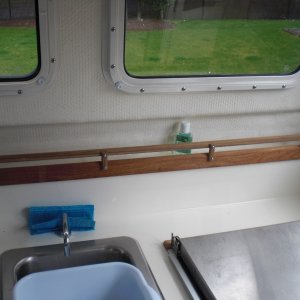Fiddle rail added to galley shelf.