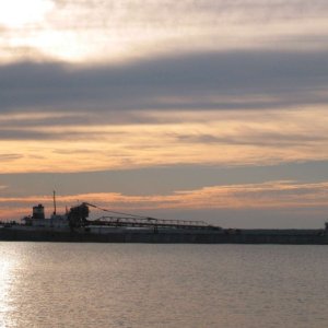 Lime Island anchorage. Self loading laker passing through channel at dusk.