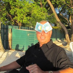 Mike Rizzo playing his cards right to block the bright setting sun in Islamorada at the 
marker 88 restaurant the waiter was particularly slow named Adonnus as I remember. notice the rest of us and Ginny taking the picture in the shadow over Mike's shoulder