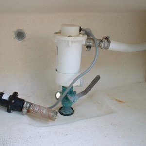 Here are some photos of the live bait well plumbed into the port laz by the dealer for the previous owner. The clear hose with check valve on the left is the intake for the manual bilge pump. This photo shows the bait pump with bronze through hull and valve.