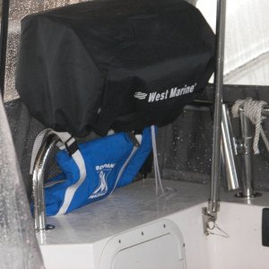 Newport grill under vinyl windows with propane bag hanging underneath.