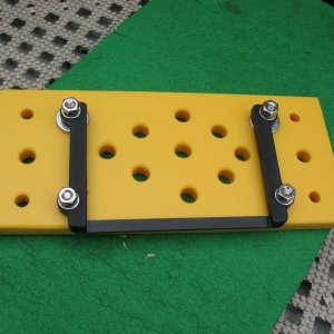 Bracket backing plate for Bennett trim tab HPU.  I wanted to be able to mount it above the starboard fuel tank, for super-efficient use of space -- but this meant I would not  be able to lift off the lid.  I also wanted to use Weld Mount studs to mount it to the hull side.  So I made a Starboard backing plate (the yellow material) and mounted Bennett's HPU bracket to it (black).  Now instead of lifting the lid from the HPU (which is not something that is done often), I instead take the yellow plate off the hull side and then move the HPU to where I can take the lid off.  I made the two sets of Weld Mount studs different lengths so that it would be easier to get the yellow plate in place (sort of like how two rudder pintles are different lengths).