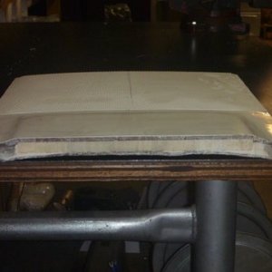 Media 'Roof piece shows two different core materials,notice grey stuff to the right and left of the center material.The top or the part which is outside in the weather looks to have about 3/16 worth of fiberglass while the inside or bottom side only has about 1/8 inch fiberglass' in album 'Pictured is a section of our roof cut for the air conditioner installation'