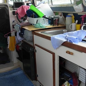 Two Bears in "living mode".  Note that cabnet door is missing and is now a flat work surface on top of helm seat.  Walls and ceiling have been lined with indoor/ outdoor carpet to 1) reduce condensation, and 2) to hold Velcro based pockets and LED lights
We purchased plastic baskets to sit on shelves which helps with organization under the sink.