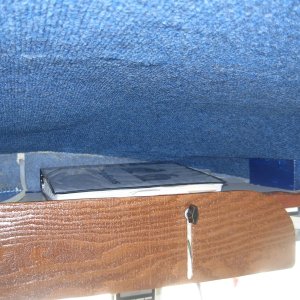 Overhead storage above center windshield.  With the original open shelf we were always being "bombed" by stuff falling from the over head bin.  I lowered the shelf by inserting a 2x2 and using longer bolts.  The front cover, or door is a piece of 1/4 ply held in place with wing nuts.  See next photo for the closed position view.  The blue "headliner" lining was our test for the headline fabric.  It worked well, but my application was poor so we had a professional do whole cabin interior with a golden brown headliner fabric.