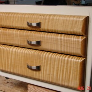 Finished drawer fronts.  Curly maple with 2 coats dark garnet shellac then 2 coats satin poly.  SS pulls from Lee Valley.