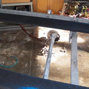This is the "what have I done?" point.  Springs are dropped and the old axle (for V hull) removed.  The new straight axle works with a C Dory.  The axle had to be drilled to fit the bolts that hold the leaf springs together.  Otherwise, it is a straight bolt-on job.