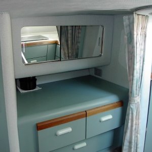 Vanity with storage behind sliding mirror and drawers below.