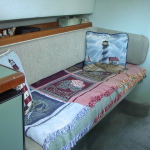 Setee that converts to small berth by sliding out and the back cushion folding inward. Storage below.