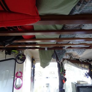 Upper rack, which has life jackets, the screen enclosure, and camper canvas stored.  The fishing rod holders on the port side, Microwave over the hanging locker, raised to clear cushion, and storage underneath.  Also a dual USB port there.