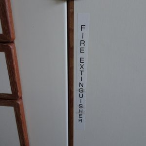 Denotation of galley fire extinguisher.  there is also a halogen "grease fire" extinguisher on top outboard of helm seat.