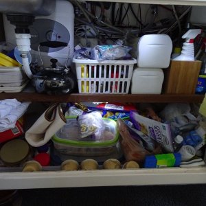 This shows the under the galley storage area, and in this case it is lit by LED lights which are on under the shelf, and from the top.  Note the water heater behind the galley sink.  Fire extinguisher to the left.